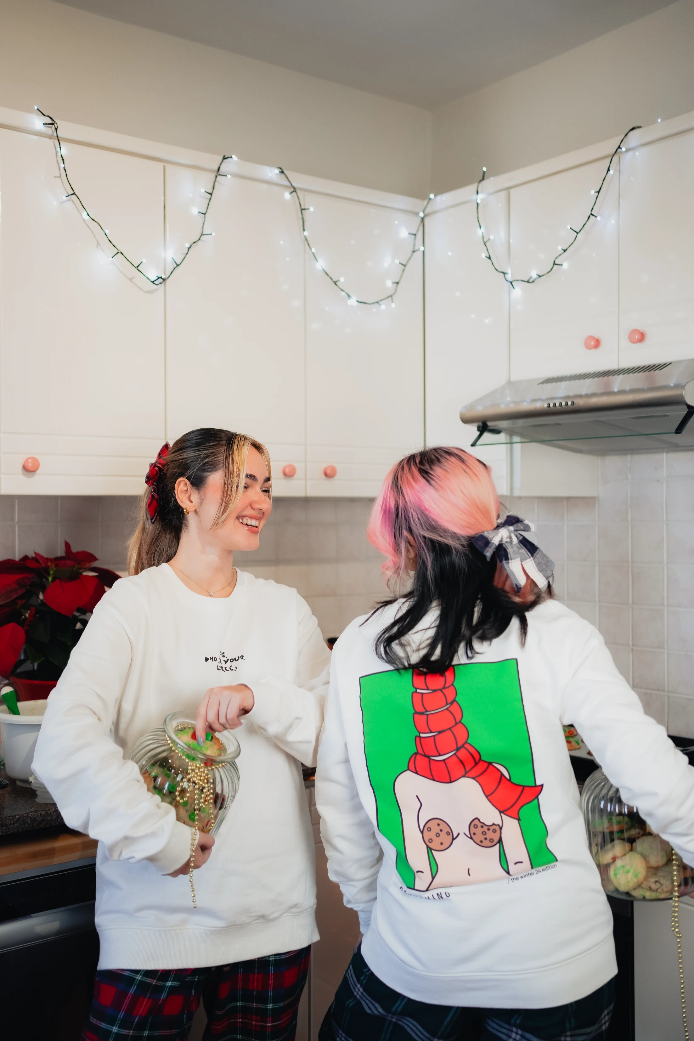 girlfriends baking together cookie in her winter 24 limited edition xmas sweatshirt - brunching collection