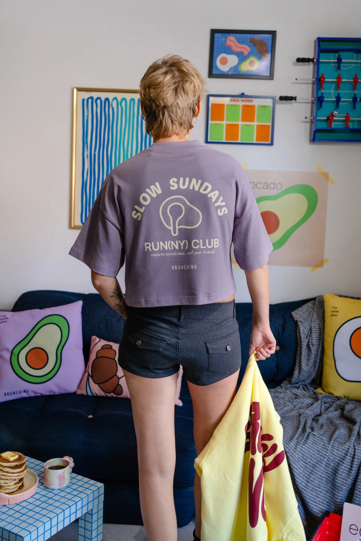 Run(ny) Club Crop Top, back view holding a yellow hoodie, model wears S